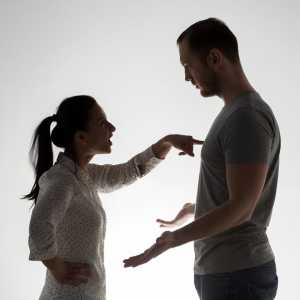 Mulher e homem. Mulher apontando para o peito do homem que faz gesto de não entender